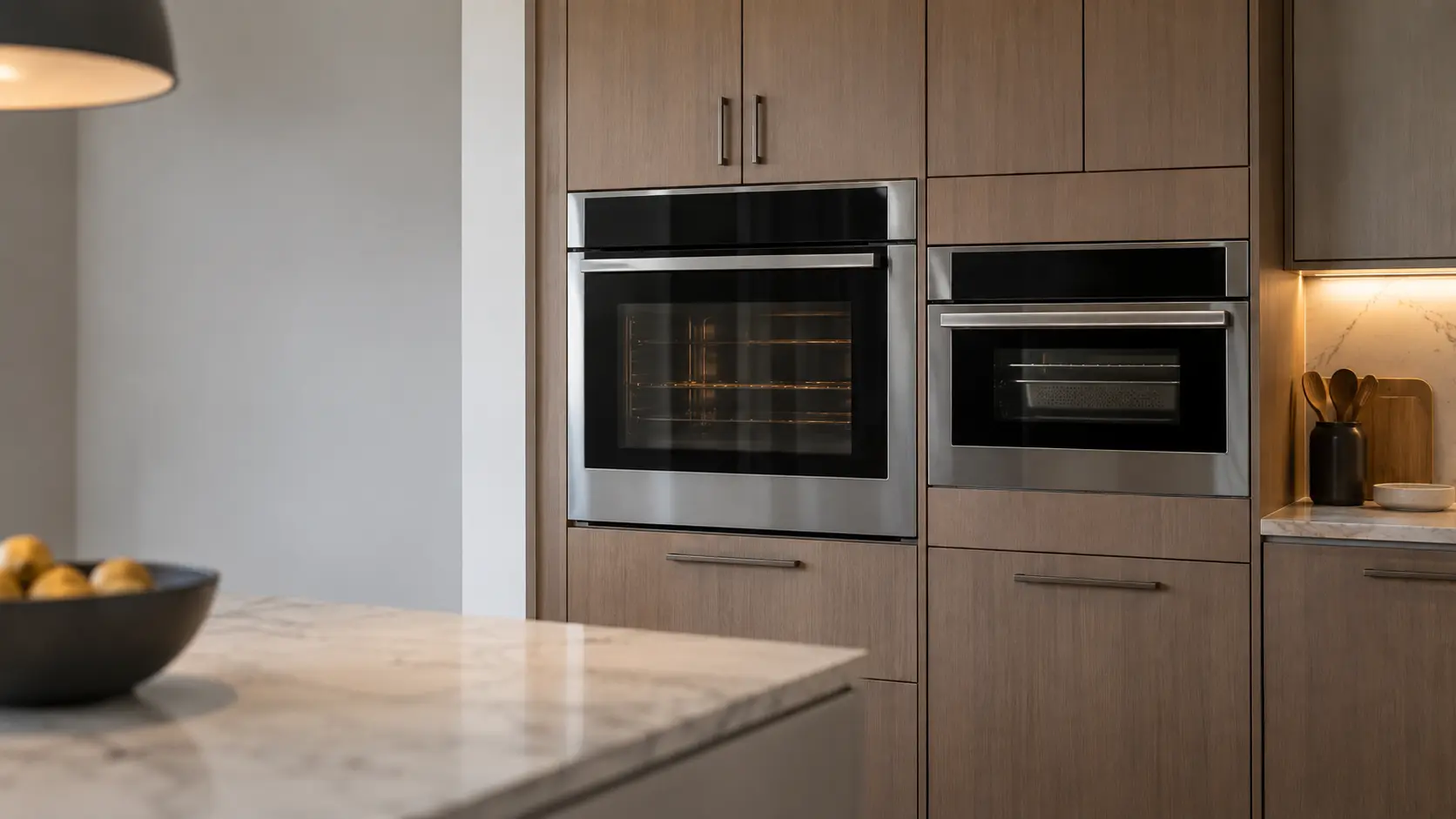 A single wall oven and a steam oven side by side in a column of kitchen cabinets.